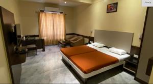 ein Schlafzimmer mit einem Bett und ein Wohnzimmer in der Unterkunft Ramakrishna International in Nanded-Waghala