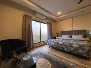 een slaapkamer met een bed en een groot raam bij *Designer’s Luxurious 1BHK at Top Location of Twin Cities!! in Rawalpindi