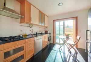 a kitchen with wooden cabinets and a table in it at Sunny apartament at Carcavelos Beach, by TimeCooler in Carcavelos