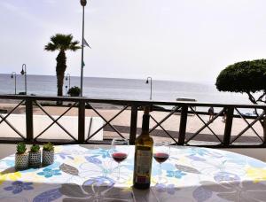 a bottle of wine sitting on a table near the beach at Casa Regla in Puerto del Carmen