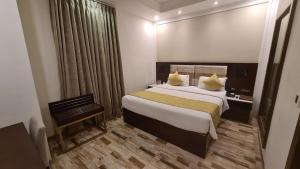 Regenta Inn Ranip Ahmedabad في أحمد آباد: غرفة فندقية بسرير كبير ونافذة