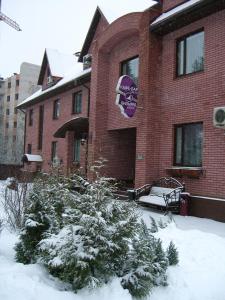 a building with snow on the ground in front of it at Iris Hotel in Aleksandrov