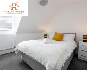 a bedroom with a white bed with a yellow pillow at 5 Beds - Free Gated Parking - City Centre - By Hinkley Homes Short Lets & Serviced Accommodation in Liverpool