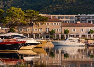 a group of boats docked in the water in a city at Lazure Hotel & Marina in Herceg-Novi