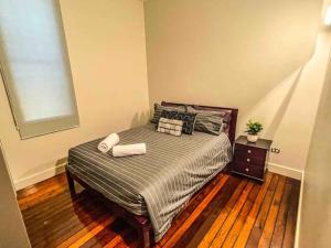 a bedroom with a bed with two towels on it at Townsville Central Apartment @ Flinders Street in Townsville