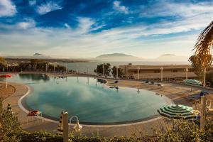 una grande piscina con vista su un bacino d'acqua di CDSHotels Terrasini - Città del Mare a Terrasini