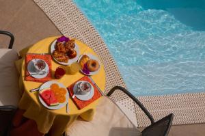 una mesa con platos de comida junto a una piscina en Arciduca Grand Hotel en Lipari