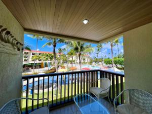 uma varanda com vista para uma piscina e palmeiras em Marulhos Muro Alto, Apartamento Encantador em Porto de Galinhas