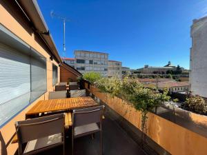 a balcony with a wooden table and chairs on a building at El Roble 9 in Astorga