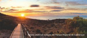 un paseo marítimo de madera que conduce al océano al atardecer en Konk Hostel en La Manga del Mar Menor