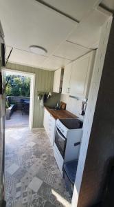 eine kleine Küche mit einer Spüle und einem Herd in der Unterkunft Neu 55min von Oslo Ferienhaus mit Aussicht Sauna Wassersport in Berger