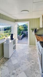 eine Küche mit einer offenen Tür zu einer Terrasse in der Unterkunft Neu 55min von Oslo Ferienhaus mit Aussicht Sauna Wassersport in Berger