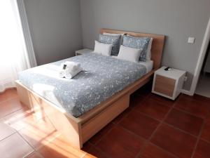 a small bedroom with a bed with blue sheets and pillows at See U Inn in Torreira