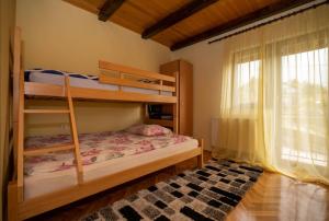sypialnia z 2 łóżkami piętrowymi i oknem w obiekcie Holiday Home Lana w mieście Fužine