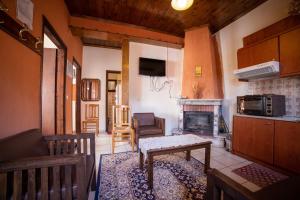 ein Wohnzimmer mit einem Tisch und einem Kamin in der Unterkunft Mprizis Rooms in Elati, Trikala