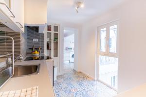 eine Küche mit einem Waschbecken und einem Fenster in der Unterkunft Liberdade Central Apartment in Lissabon