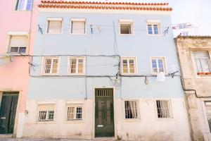 ein altes weißes Gebäude mit grüner Tür in der Unterkunft Liberdade Central Apartment in Lissabon