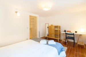Schlafzimmer mit einem Bett, einem Schreibtisch und einem Tisch in der Unterkunft Liberdade Central Apartment in Lissabon
