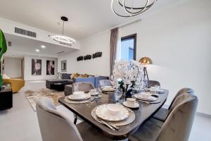 comedor y sala de estar con mesa y sillas en Primestay - Nasayem Avenue in Mirdif Hills, en Dubái