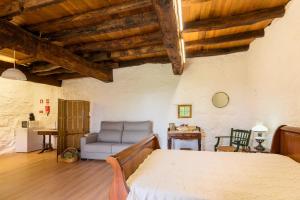 a bedroom with a bed and a chair in a room at Casa Lavoura em Requeixo in Celorico de Basto