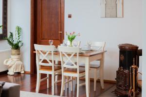 uma sala de jantar com uma mesa e cadeiras brancas em Gdynia Centrum Apartament przy Promenadzie by Renters em Gdynia
