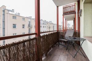d'un balcon avec une table et une vue sur un bâtiment. dans l'établissement Gdynia Centrum Apartament przy Promenadzie by Renters, à Gdynia