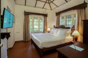 a bedroom with a large bed in a room with windows at MAI HOUSE HERITAGE HOTEL in Fort Kochi