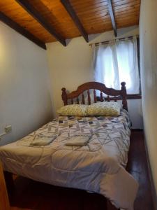 um quarto com uma cama com uma cabeceira em madeira e uma janela em El Balcon em Ushuaia