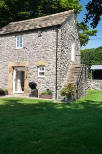 a small stone house with a grass yard at Long Roods cottage in Bakewell