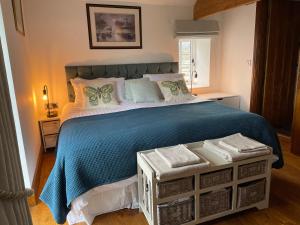 um quarto com uma cama grande e um cobertor azul em Long Roods cottage em Bakewell