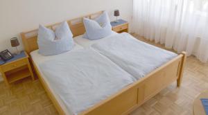 een slaapkamer met 2 bedden met witte lakens en kussens bij Hotel im Homburger Ländchen in Nümbrecht