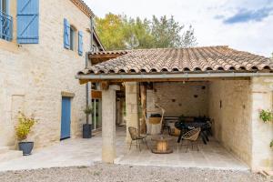 a patio with chairs and a table in front of a building at Gite Pierre qui roule in Castanet