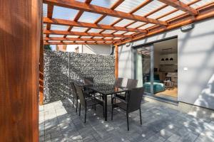 a dining room with a table and chairs on a patio at Apartmány Oravskie in Zuberec
