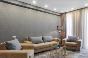 Vinum Hotel في تبليسي: غرفة معيشة مع أريكة وكرسيين