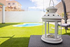 una casetta per uccelli bianca seduta su un tavolo in un cortile di Villa Samperez Piscina Jardin 5 Dormitorios 12 Personas a Las Palmas de Gran Canaria