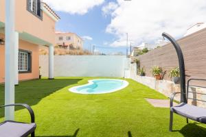 a backyard with a small pool in the grass at Villa Samperez Piscina Jardin 5 Dormitorios 12 Personas in Las Palmas de Gran Canaria