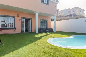 una casa con un patio con piscina en Villa Samperez Piscina Jardin 5 Dormitorios 12 Personas, en Las Palmas de Gran Canaria