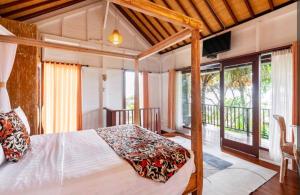 a bedroom with a bed and a balcony at Sunsets at Sumbul in Pulukan