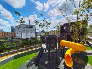 a playground with a yellow slide in a park at Maxhome at Lucentia Bukit Bintang City centre KL in Kuala Lumpur