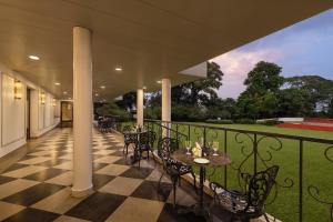 patio ze stołami i krzesłami na balkonie w obiekcie Fortune Valley View, Manipal - Member ITC's Hotel Group w mieście Manipala