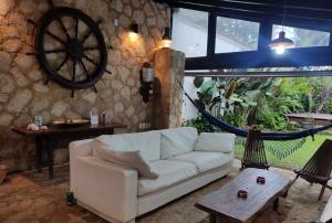 a living room with a white couch and a wheel at Casa rústica centenária no Centro Histórico de Paraty - Wifi 120MB in Paraty