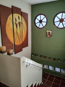 baño con pinturas en la pared y lavamanos en Recanto Dom José, en Peruíbe