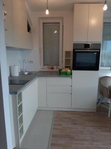 a white kitchen with a sink and a microwave at Vrnačka Banja Apartman Paeonia in Vrnjci