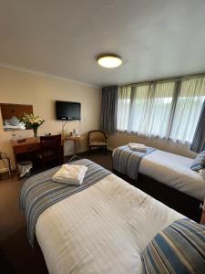 a hotel room with two beds and a television at Hermitage Park Hotel in Coalville