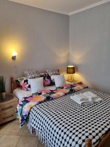 a bedroom with a bed with a black and white comforter at Hotel "ZAUŁEK" Spółka Cywilna Zbigniew Świderski, Elżbieta Świderska in Olszyna