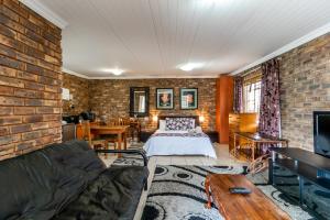 a living room with a brick wall at Berghaan Pretoria in Pretoria