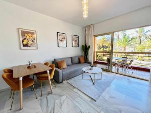 een woonkamer met een bank en een tafel bij 797 Holiday Rentals- Apartamento en Hotel Sunset Beach frente al mar in Benalmádena