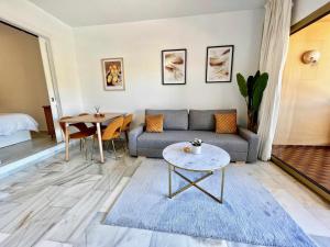 salon z kanapą i stołem w obiekcie 797 Holiday Rentals- Apartamento en Sunset frente al mar w mieście Benalmádena