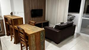 a living room with a couch and a television at Flat Brookfield Towers 2309 in Goiânia