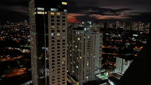 a tall building in a city at night at Flat Brookfield Towers 2309 in Goiânia